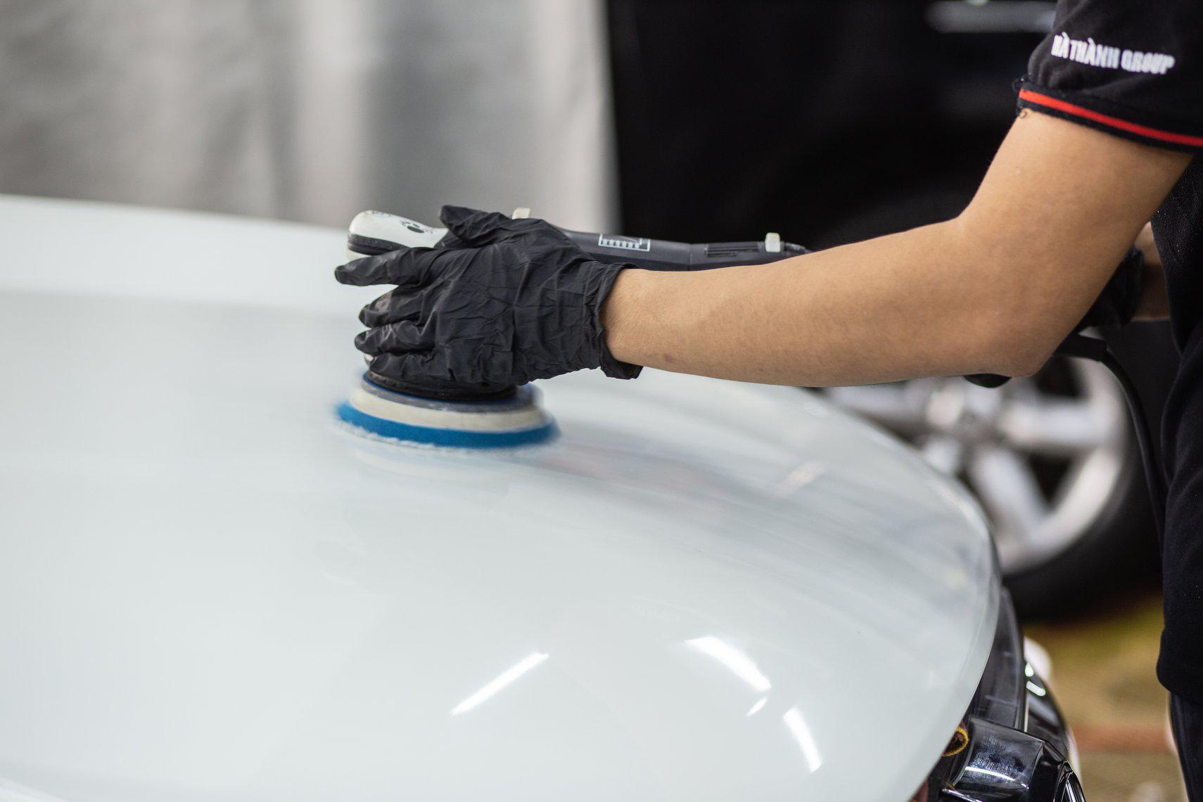 Hình ảnh nhân viên kỹ thuật thi công đánh bóng bề mặt sơn xe ô tô